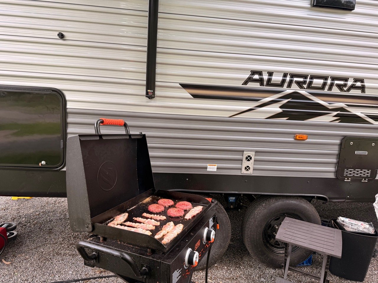 Our folding Blackstone On the Go griddle set up beside our Aurora travel trailer