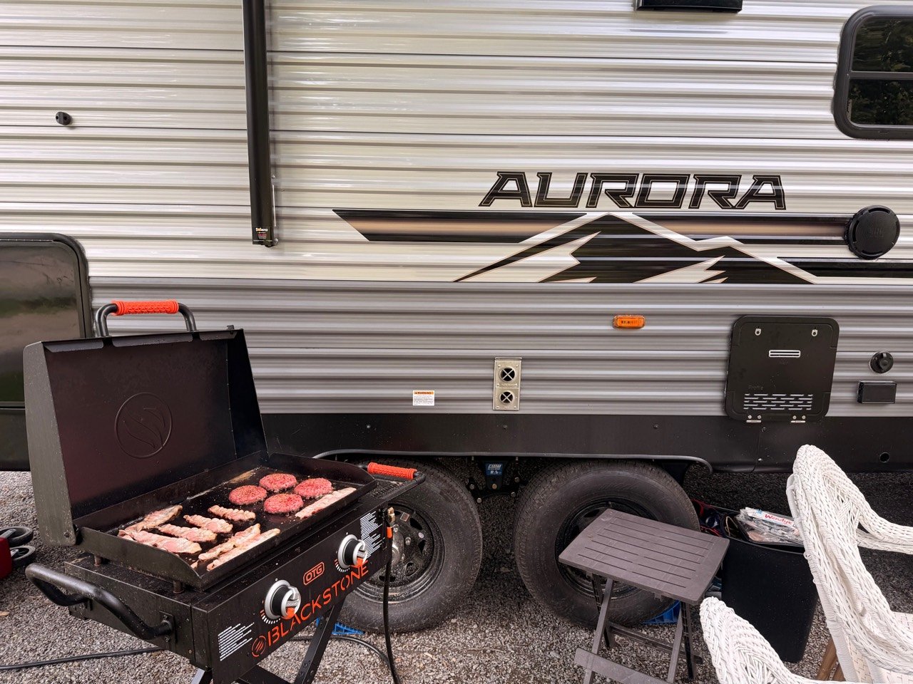 Blackstone On the Go griddle connected by propane hose beside our Aurora camper