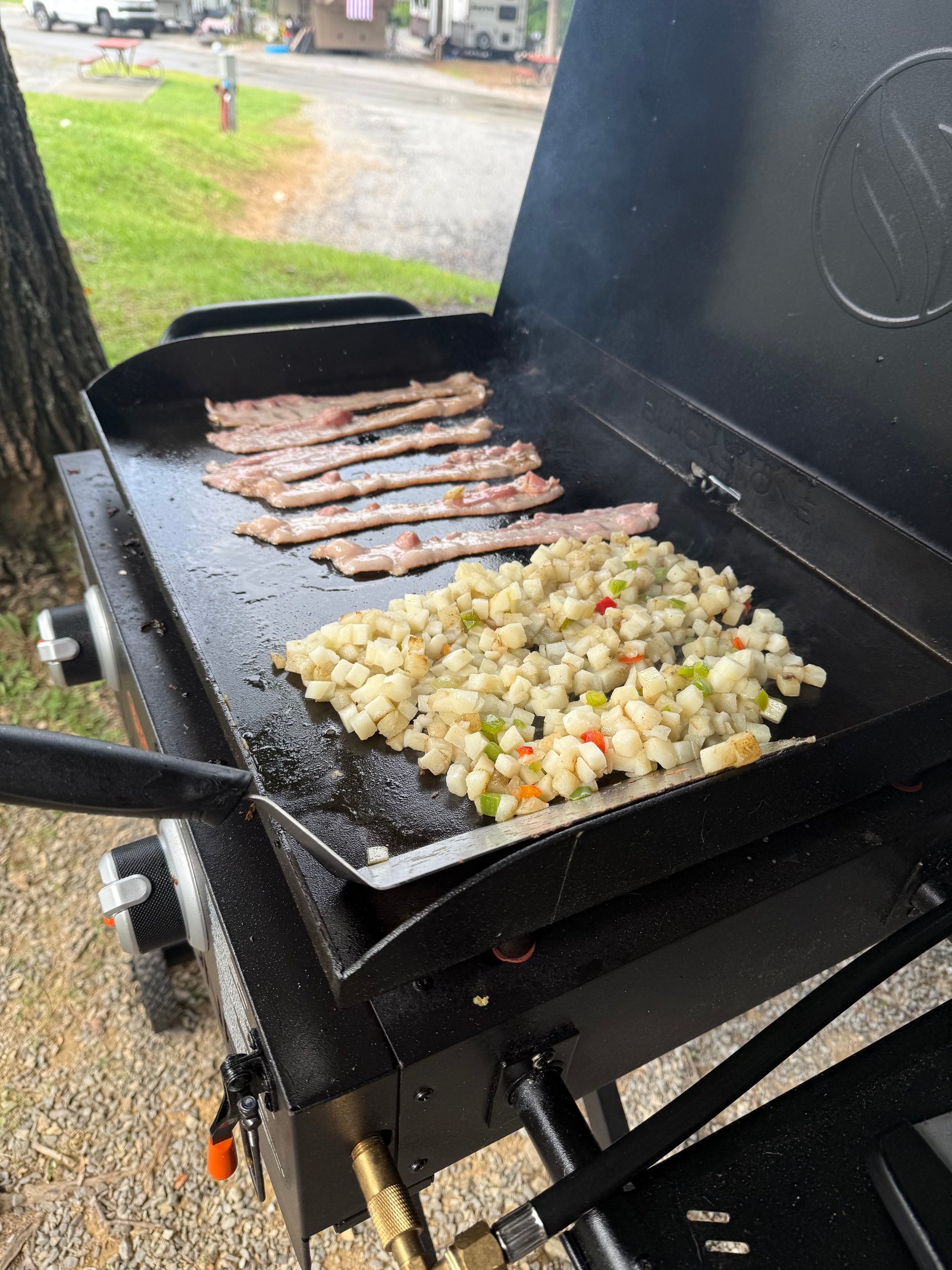 Bacon and chopped potatoes with peppers cooking on our Blackstone griddle
