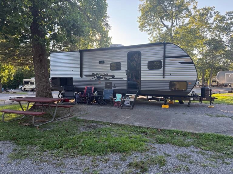 Family travel trailer set up at a wooded campground