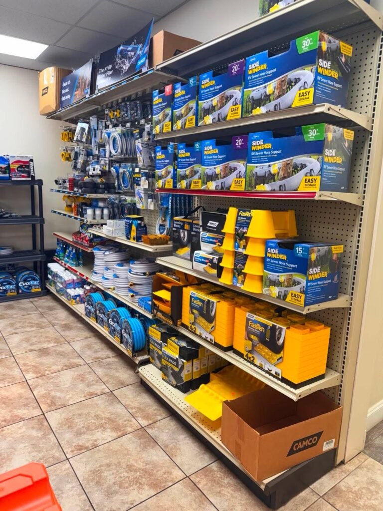 Camp-store shelves stocked with Camco and FasTen RV leveling blocks, jack pads, wheel chocks and other campsite setup supplies.